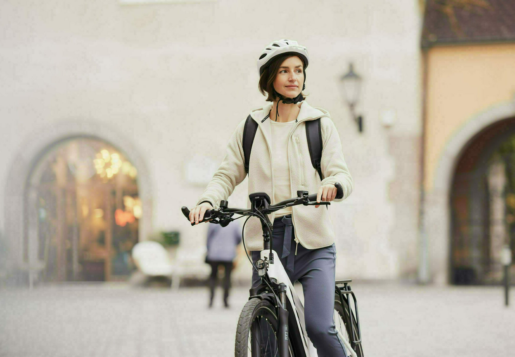 Arbeitnehmerin mit Firmenfahrrad auf dem Weg zur Arbeit
